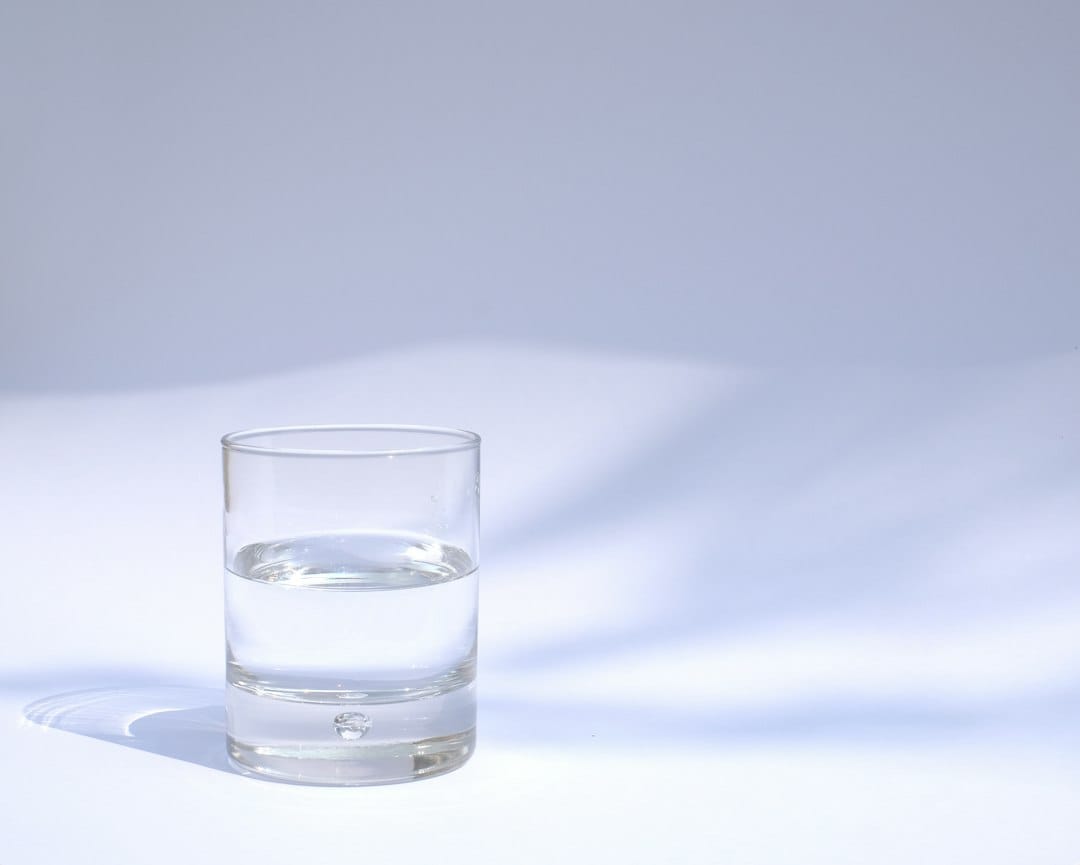 Glass of water representing gentle hydration and oral care after extraction