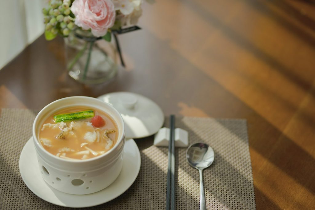 A bowl of soft chicken rice soup with tender rice in broth, a gentle meal idea after wisdom teeth removal