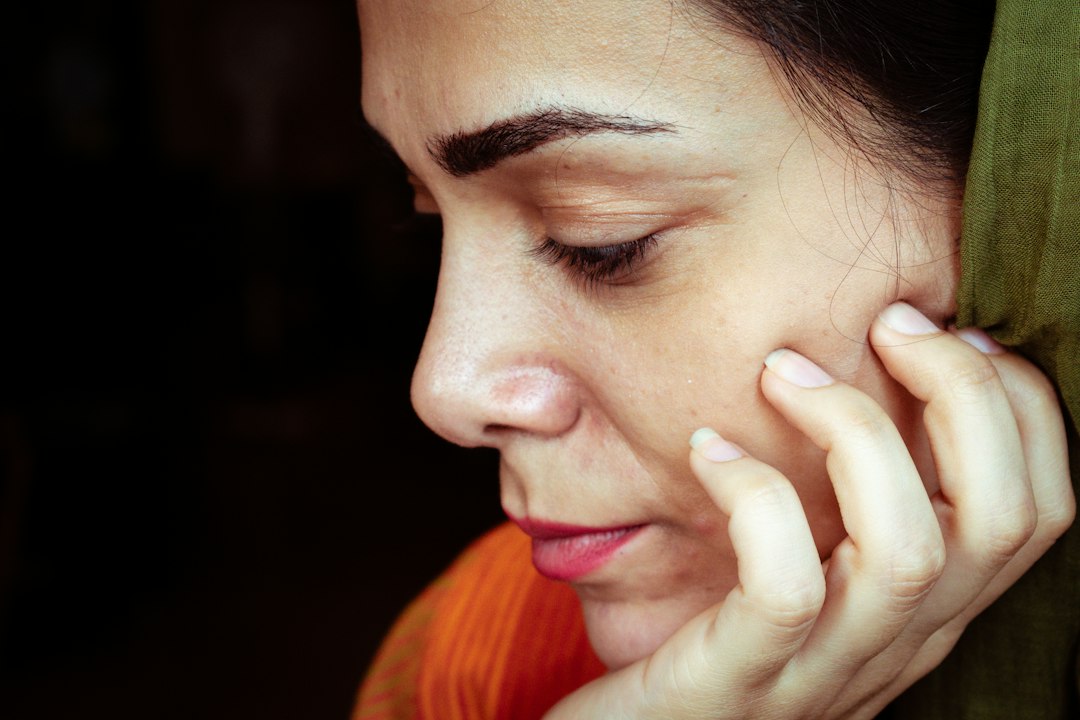 Person holding their cheek while experiencing jaw or tooth discomfort
